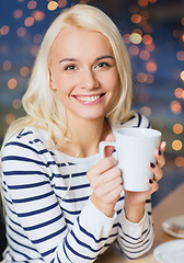 Image showing happy young woman with tea or coffee cup