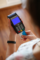 Image showing Hand putting plastic card into credit card terminal