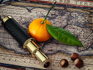 Image showing vintage telescope and mandarine at antique map