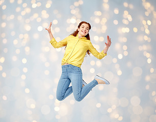 Image showing smiling young woman jumping in air