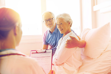 Image showing senior woman and doctor with clipboard at hospital