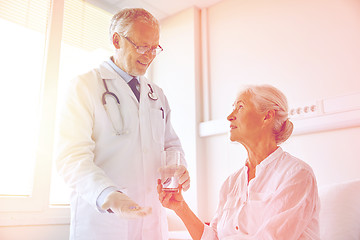 Image showing doctor giving medicine to senior woman at hospital