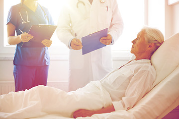 Image showing doctor and nurse visiting senior woman at hospital