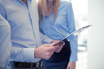 Image showing close up of business team looking at clipboard