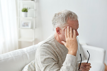 Image showing senior man suffering from headache at home