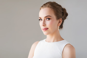 Image showing smiling woman in white dress with diamond jewelry