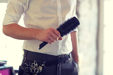 Image showing close up of male stylist with brush at salon