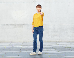 Image showing happy asian young woman pointing finger on you