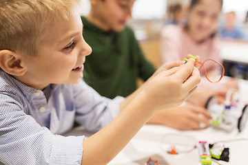 Image showing close up of boy building robot at robotics school