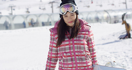 Image showing Cute and happy female asian snowboarder