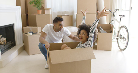 Image showing Happy mixed race couple having fun break with unpacking