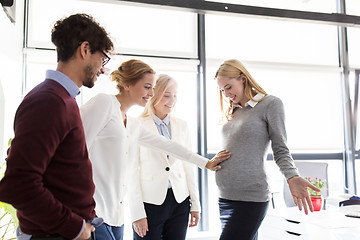 Image showing happy colleagues with pregnant woman at office