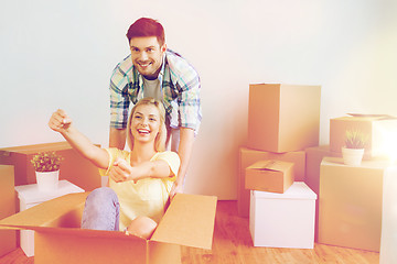 Image showing happy couple having fun with boxes at new home