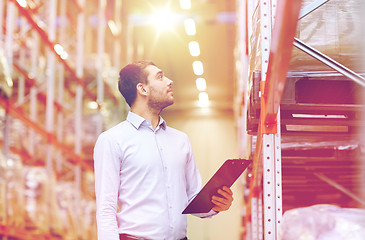 Image showing happy businessman with clipboard at warehouse