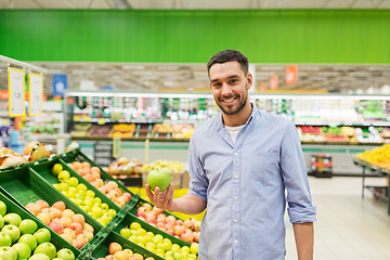Image showing happy man buying green apples at grocery store