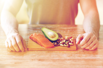 Image showing close up of male hands with food rich in protein