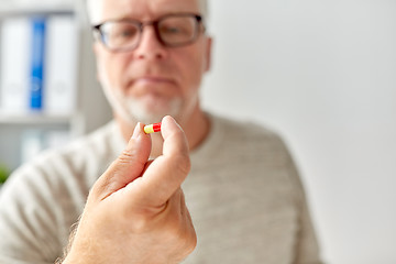 Image showing close up of old man hand with pill