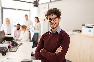 Image showing happy young man over creative team in office