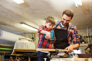 Image showing father and son with drill working at workshop