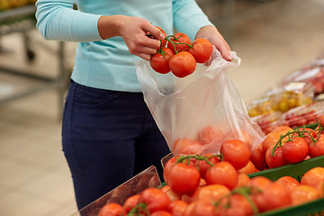 Image showing woman with bag buying tomatoes at grocery store