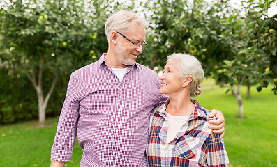 Image showing happy senior couple hugging at summer garden