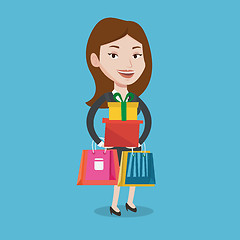 Image showing Happy woman holding shopping bags and gift boxes.