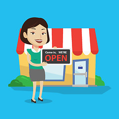 Image showing Female shop owner holding open signboard.