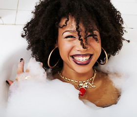 Image showing young afro-american girl in a black bikini sitting in bath, wear