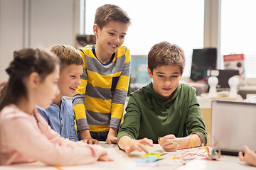 Image showing happy children building robots at robotics school