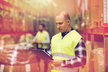 Image showing man with clipboard in safety vest at warehouse