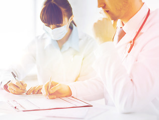 Image showing doctor and nurse writing prescription paper