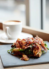 Image showing prosciutto ham salad on stone plate at restaurant