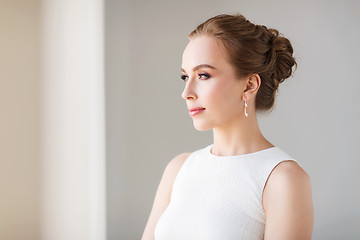 Image showing smiling woman in white dress with diamond jewelry