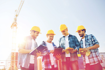 Image showing group of smiling builders with tablet pc outdoors