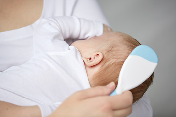 Image showing close up of mother brushing newborn baby hair