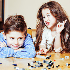 Image showing funny cute children playing lego at home, boys and girl smiling, first education role lifestyle close up