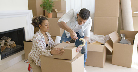 Image showing Young couple packing boxes to move home