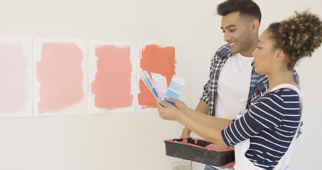 Image showing Young couple checking paint swatches