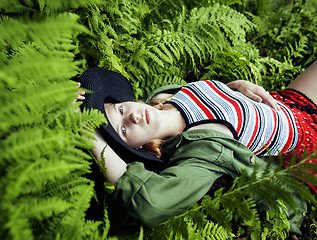 Image showing Pretty young blond girl hipster in hat among fern, vacation in green forest 