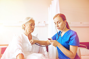 Image showing nurse with stethoscope and senior woman at clinic