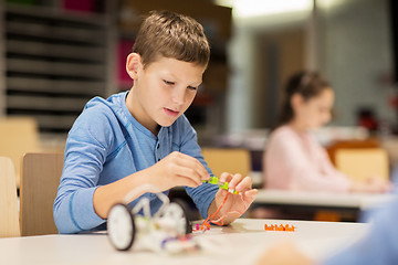 Image showing close up of boy building robot at robotics school