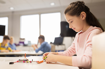 Image showing happy girl building robot at robotics school