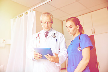 Image showing senior doctor and nurse with tablet pc at hospital