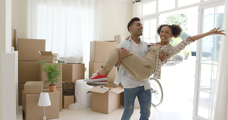 Image showing Ecstatic young couple celebrating their new home