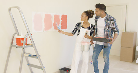 Image showing Young couple discussing shades of paint color