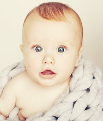 Image showing little cute red head baby in scarf all over him close up isolate