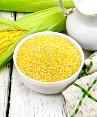 Image showing Corn grits in bowl with milk on board