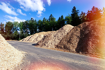 Image showing storage of wooden fuel against blue sky