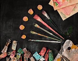 Image showing paint brushes and tubes of oil paints on wooden background