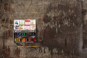 Image showing paint brushes and tubes of oil paints on wooden background